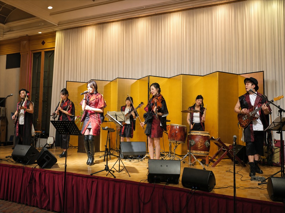 宴会場のステージ全体でヴォーカル、ヴァイオリン、和太鼓などを演奏するライブバンド